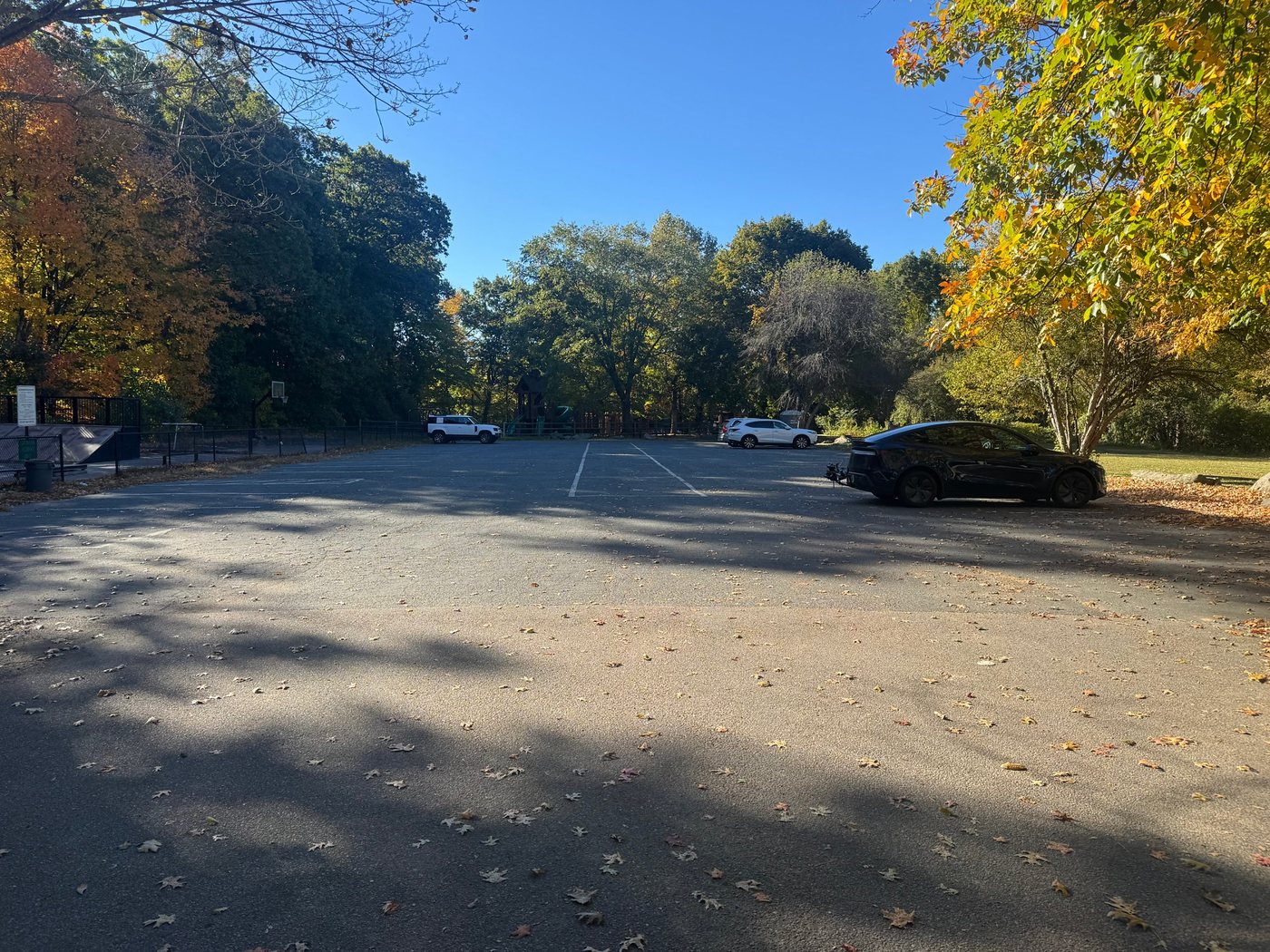The Cemetery Lane parking lot, with the skate park and a basketball hoop on the left and Sherborn Playground in the trees beyond