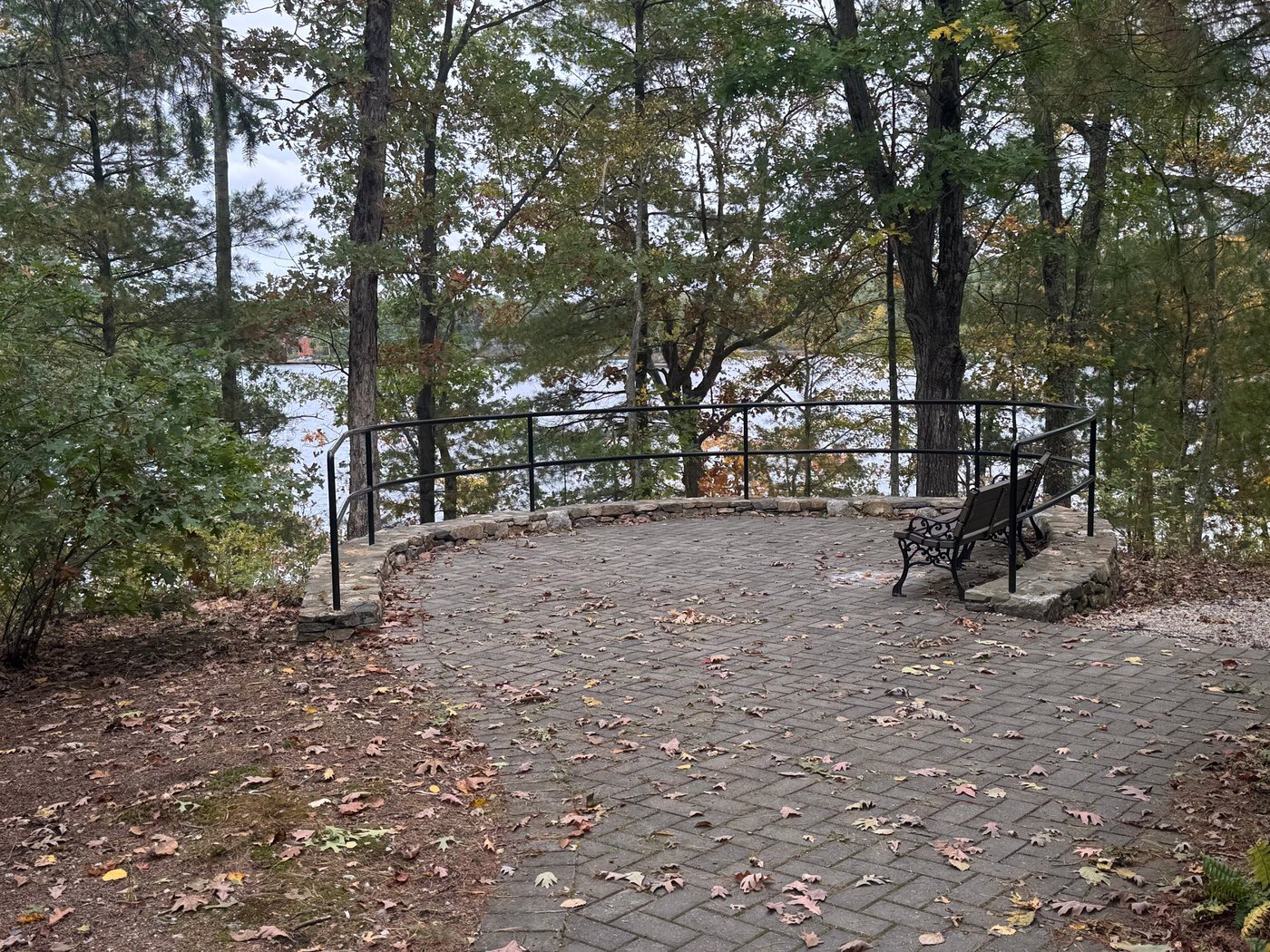 A stone-walled lookout with a bench above Farm Pond