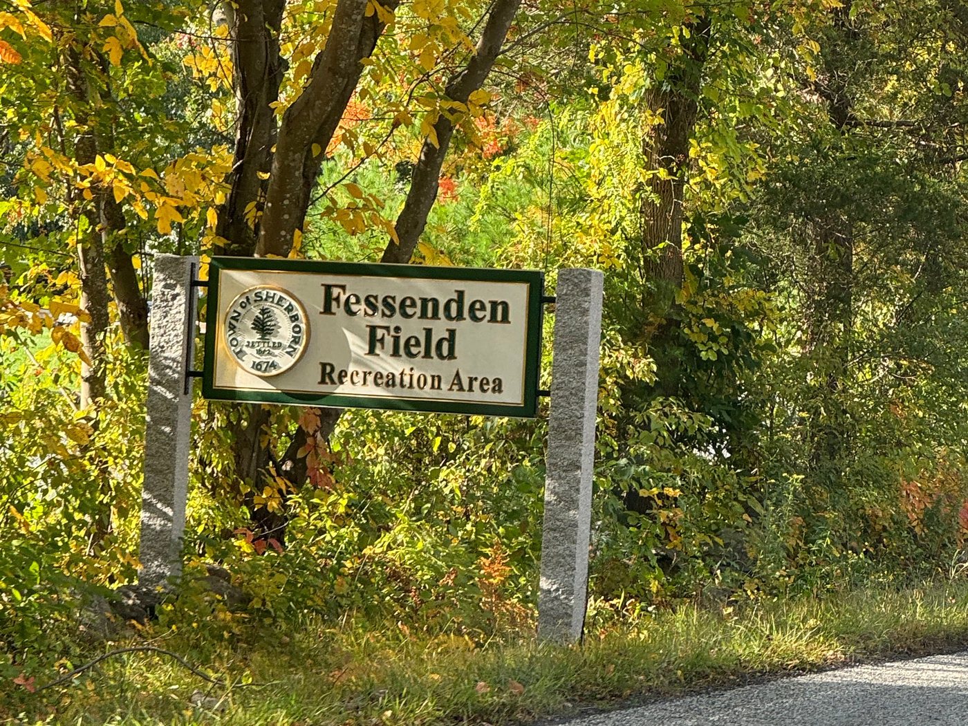 The Fessenden Field Recreation Area sign on granite posts, framed by fall foliage