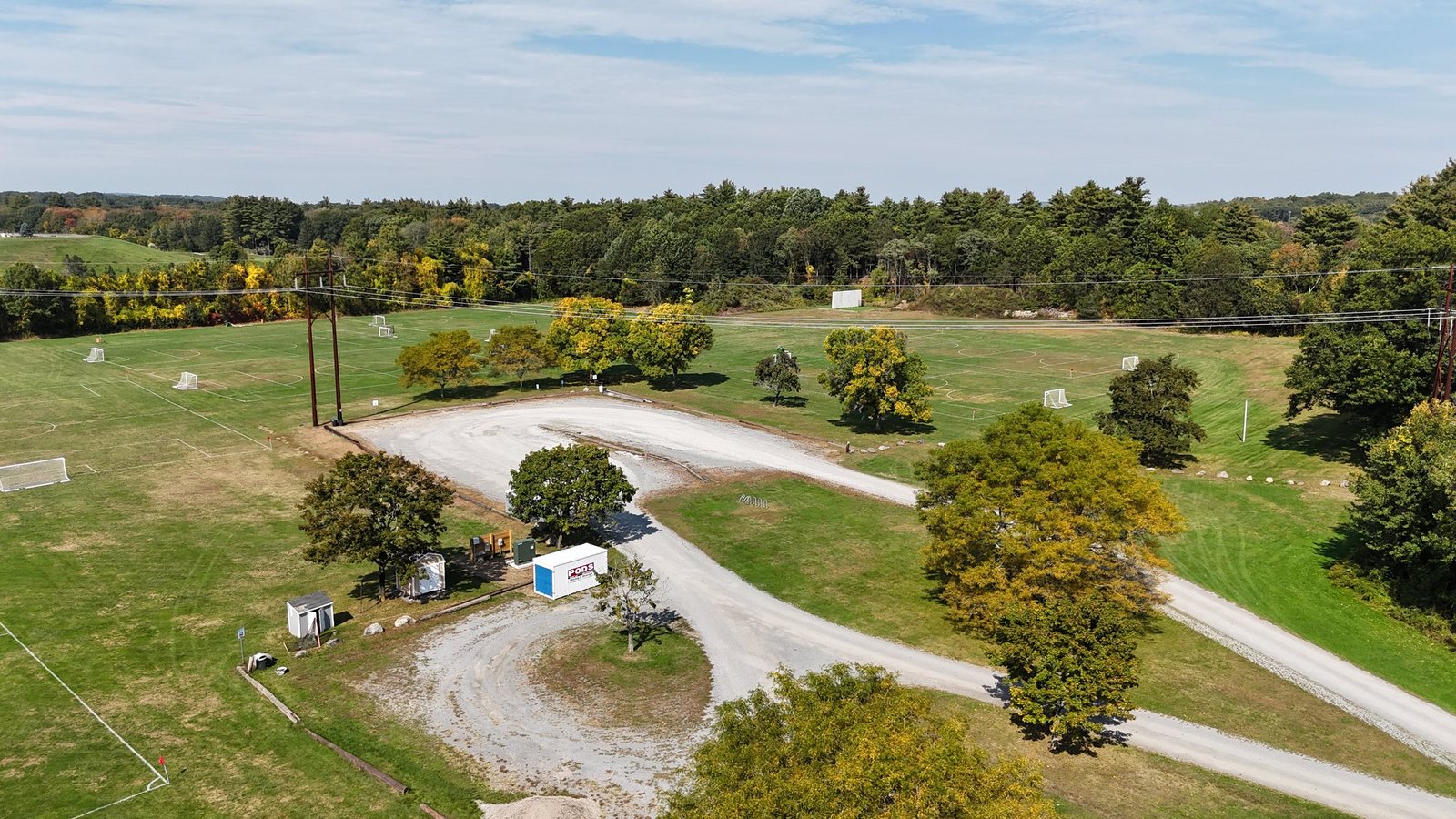 Aerial view of the gravel parking loop at Laurel Farm, with rows of youth soccer fields on both sides