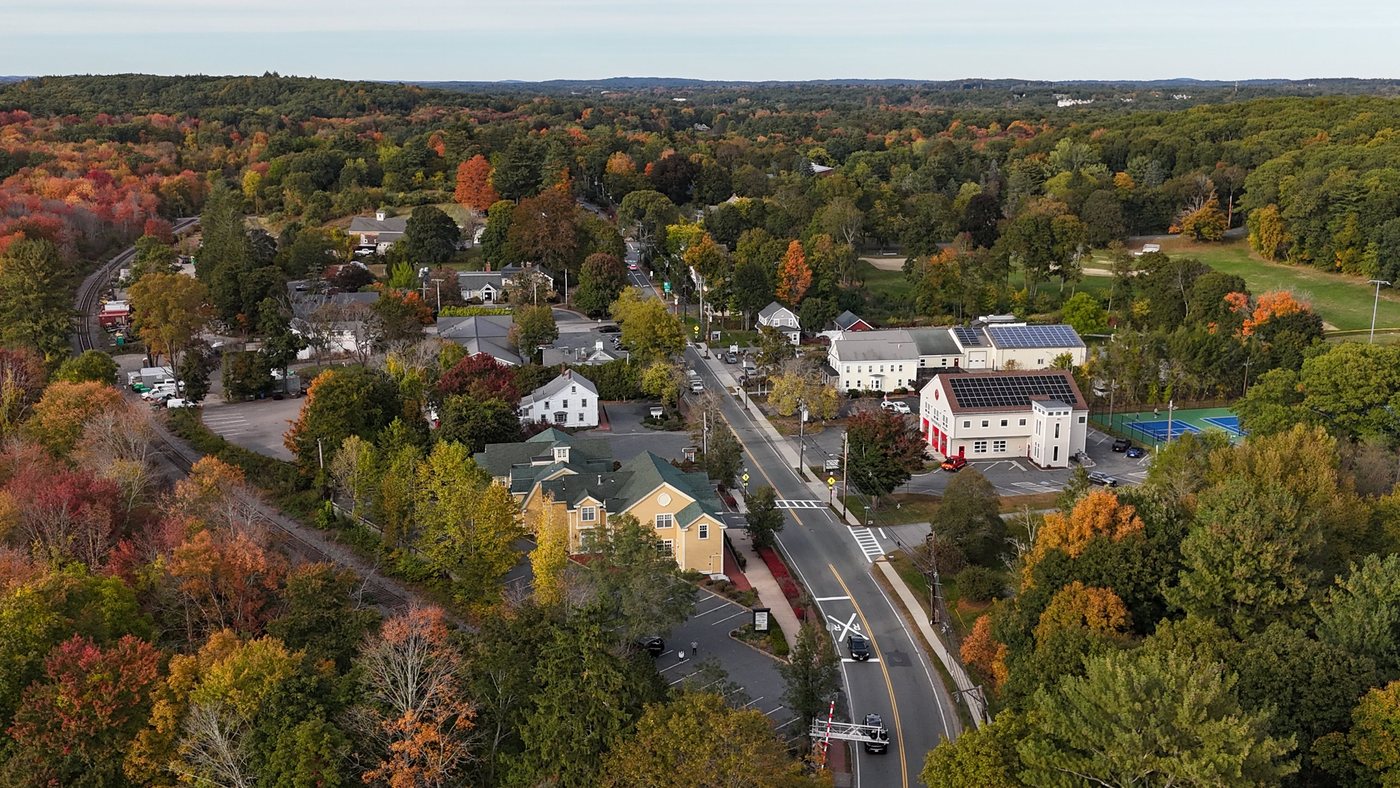Aerial view of North Main Street in Sherborn in fall, with shops, restaurants, and the fire station