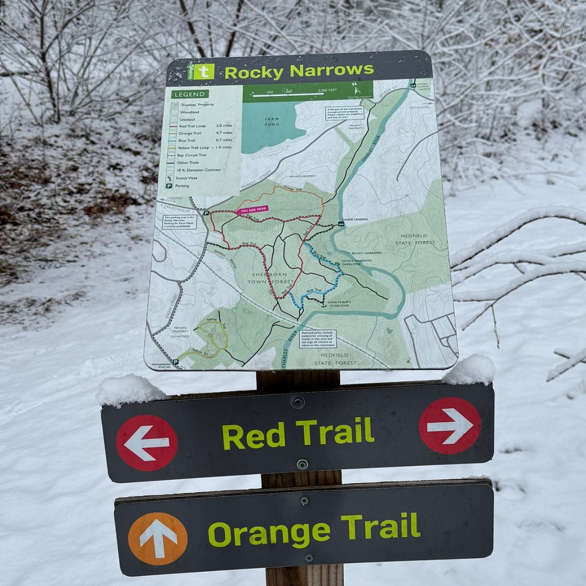 The Rocky Narrows trail map sign in winter, with Red Trail and Orange Trail markers