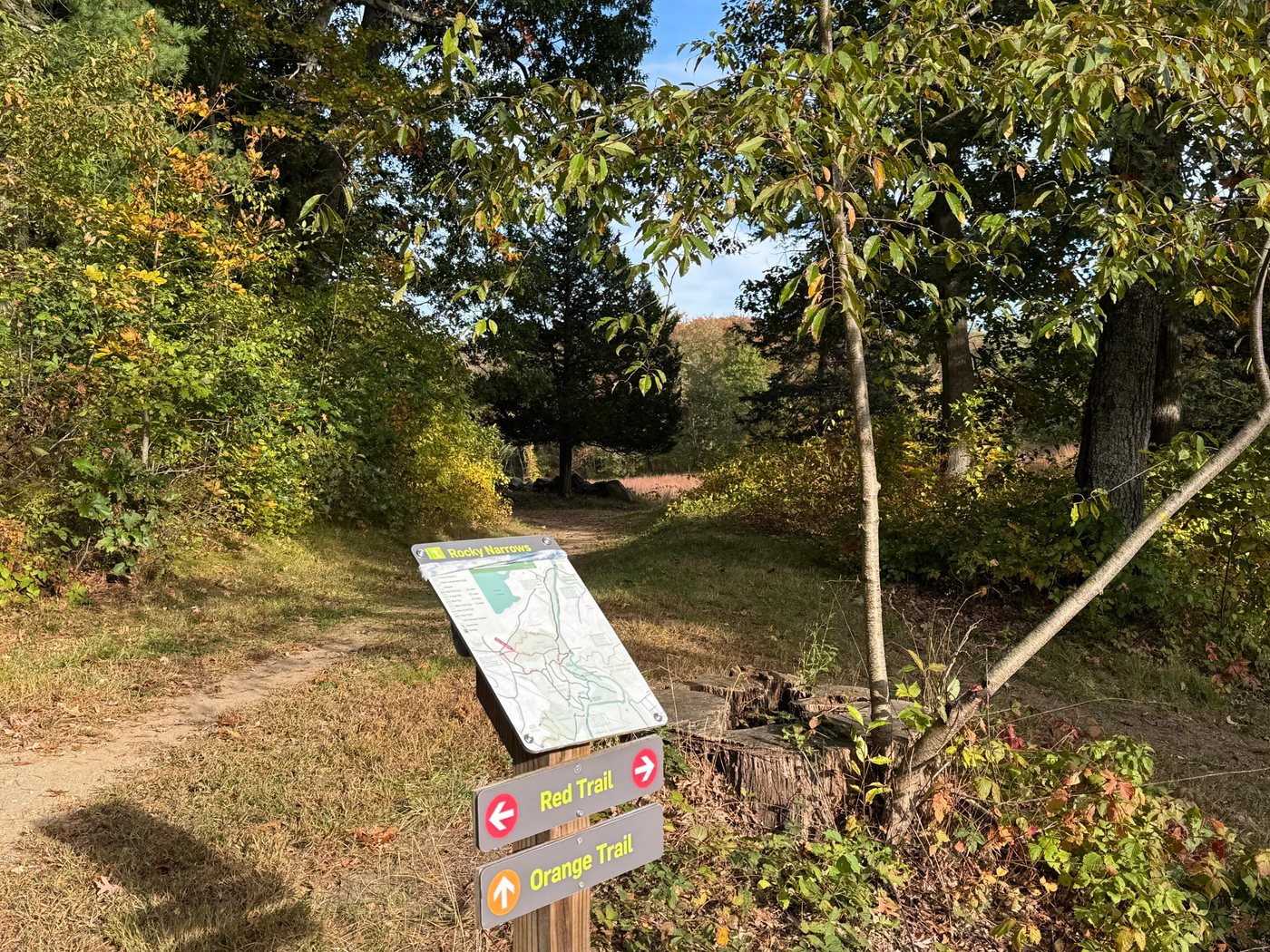 A Rocky Narrows trail map sign with arrows for the Red Trail and Orange Trail