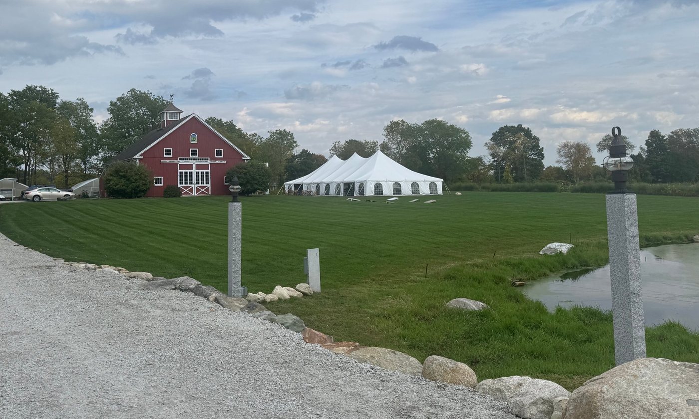 Silverwood Organic Farm’s red barn and a white event tent beside a farm pond